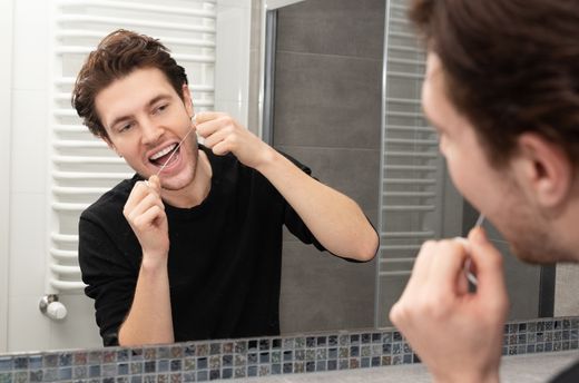 man flossing his teeth