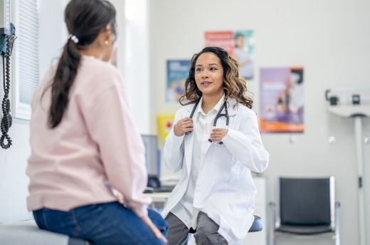 Woman talking to doctor in clinical setting